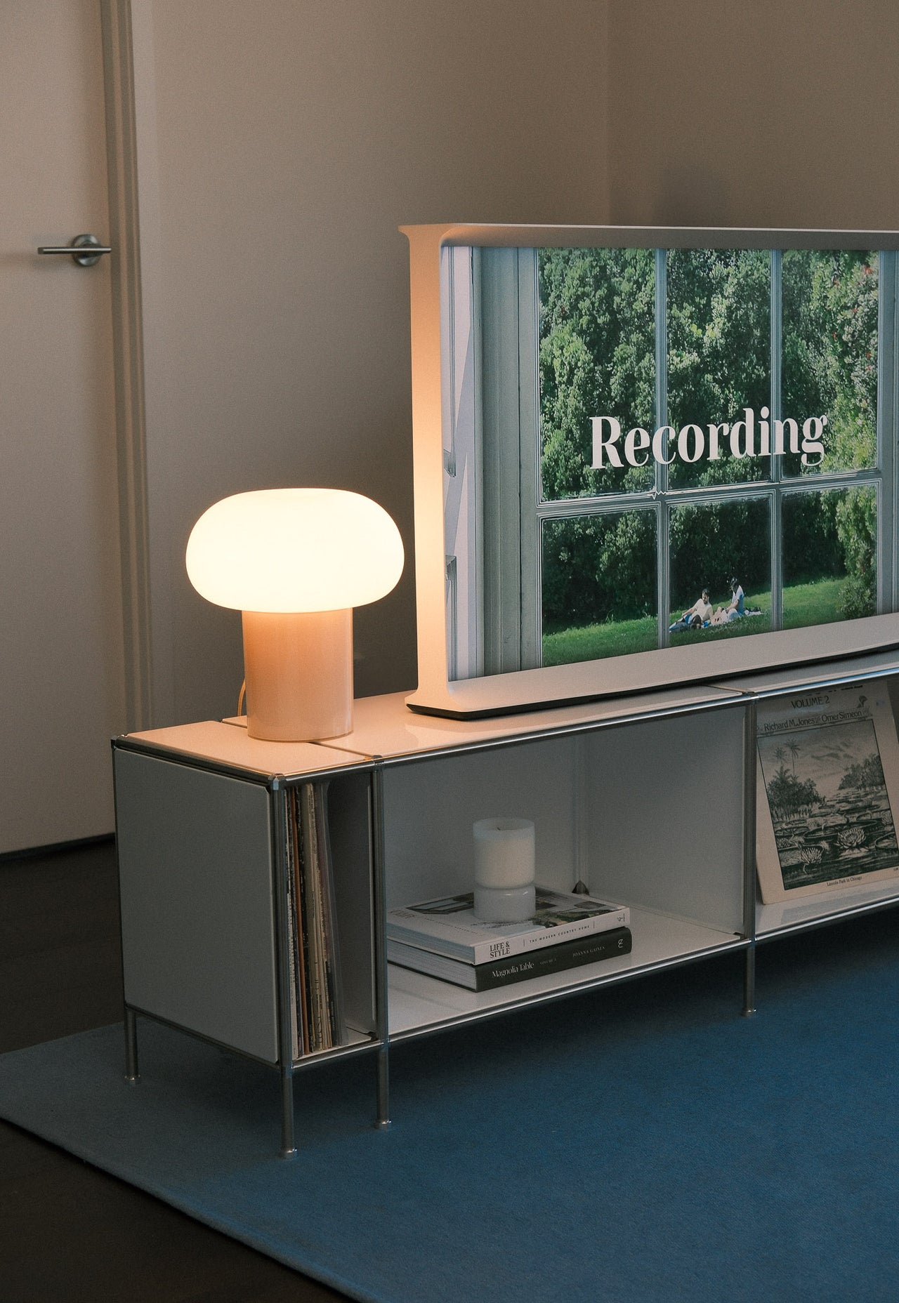 Minimal mid-century modern TV stand with lamp and decor.