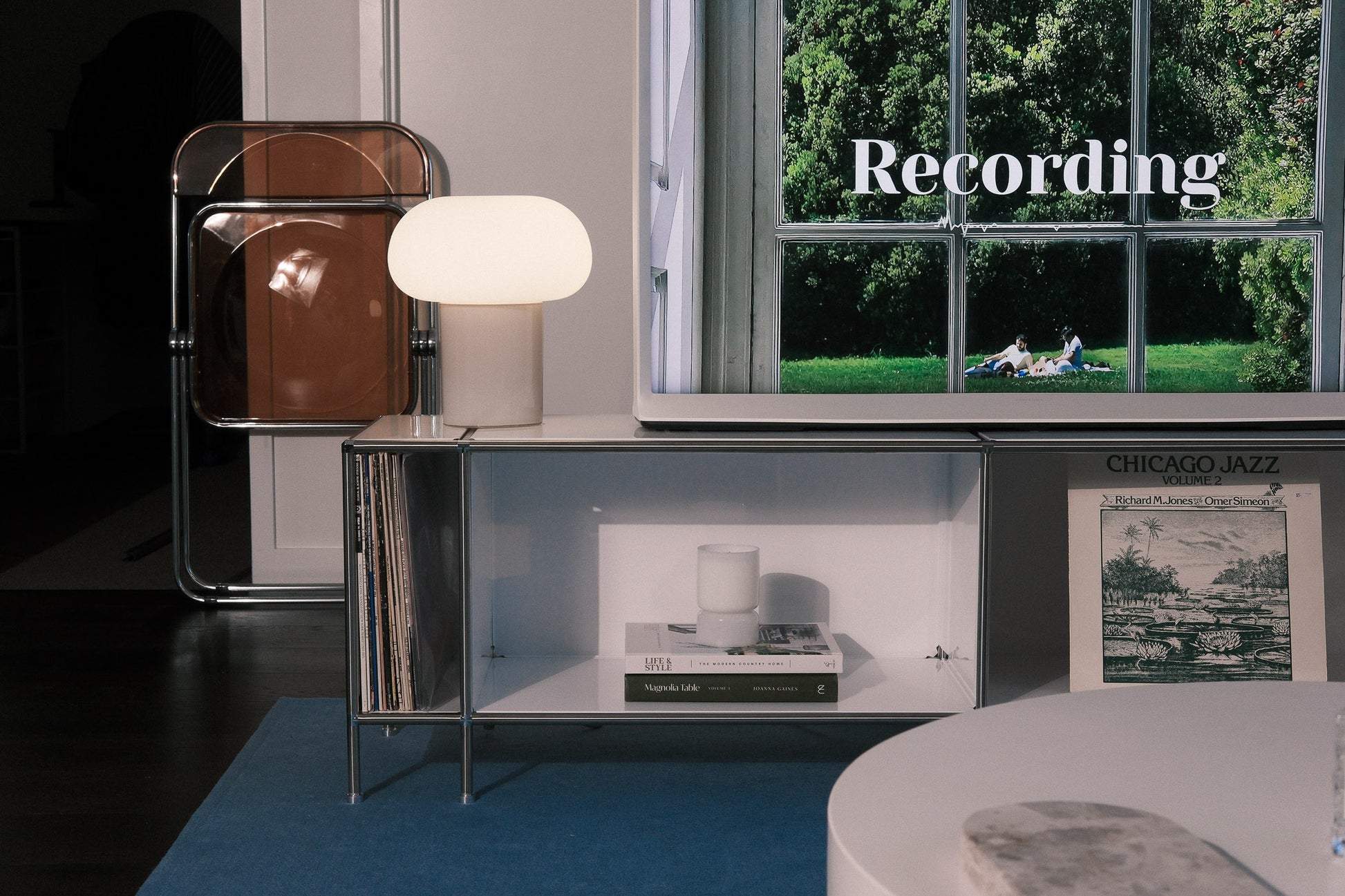 Modern entertainment center with lamp and vinyl records.